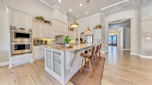 a kitchen with stainless steel appliances kitchen island granite countertop a stove a sink and a refrigerator