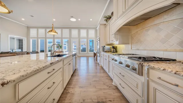 a large kitchen with stainless steel appliances granite countertop a stove and a sink