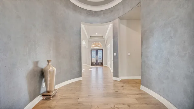 a view of a hallway with wooden floor and staircase