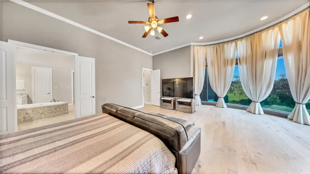 a bedroom with a bed a window and a flat screen television