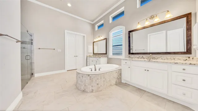 a spacious bathroom with a double vanity sink mirror and a bathtub