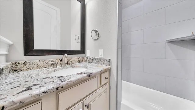a bathroom with a granite countertop sink and a mirror