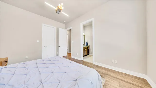 a spacious bedroom with a bed and a chandelier