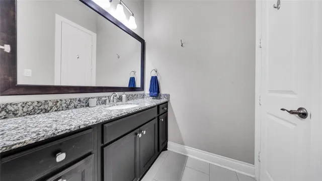 a bathroom with a granite countertop sink and a mirror