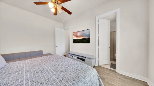 a bedroom with a bed and a flat tv screen on the dresser