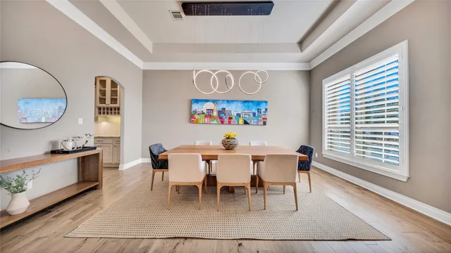 a dining room with wooden floor and a chandelier