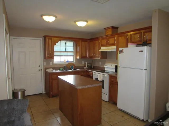 a kitchen with cabinets a refrigerator and a sink