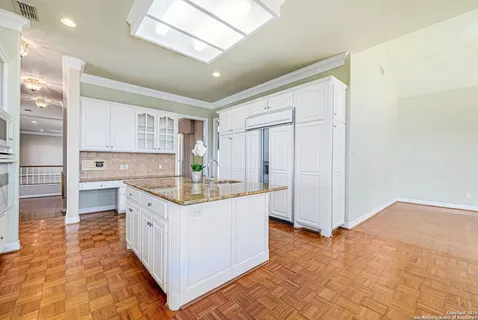 a view of a hallway with wooden floor and chandelier