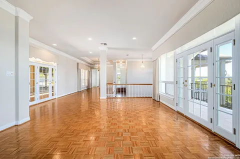 a view of an empty room with a chandelier fan