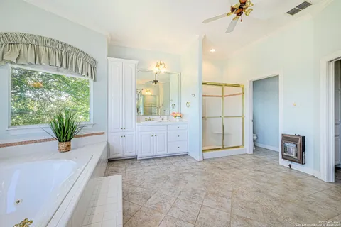 a bathroom with a sink a vanity a mirror and a bathtub with shower