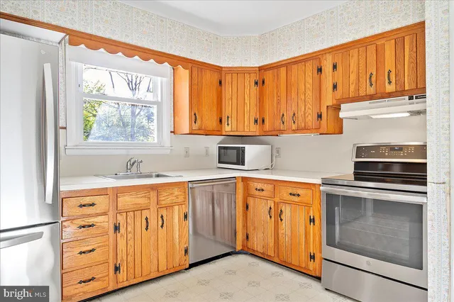 a kitchen with stainless steel appliances granite countertop a refrigerator and a stove top oven