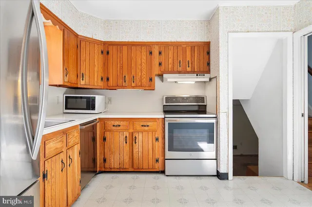 a kitchen with stainless steel appliances granite countertop a refrigerator and a stove