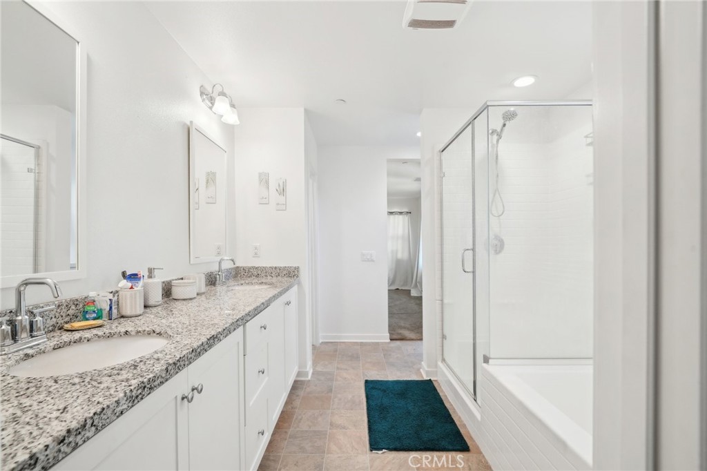 36927 Arezzo Court Beaumont, CA 92223 - Photo 20 of 53 a bathroom with a granite countertop sink a mirror and a bathtub
