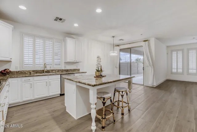 a kitchen with granite countertop white cabinets and white appliances