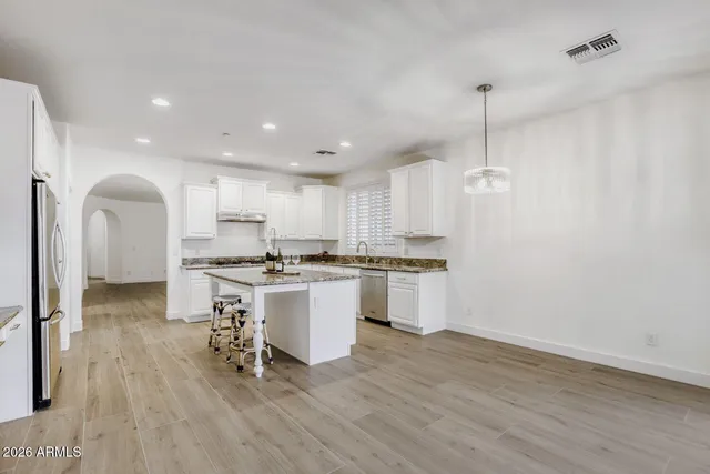 a kitchen with a sink cabinets and wooden floor