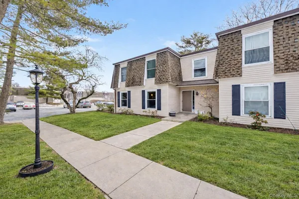 a view of a house with a yard porch and a tree