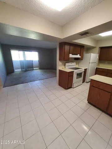 a large white kitchen with a sink and dishwasher a stove top oven with wooden floor