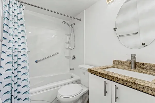 a bathroom with a granite countertop sink a toilet and shower