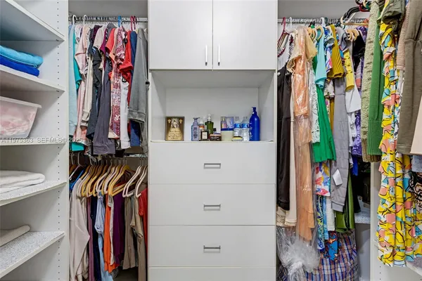 a view of walk in closet with clothes