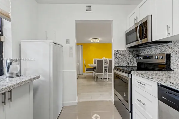 a kitchen with stainless steel appliances granite countertop a refrigerator stove microwave and sink