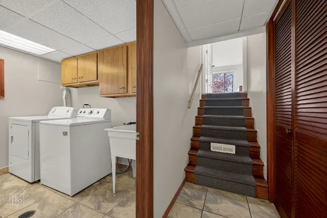 a utility room with cabinets washer and dryer