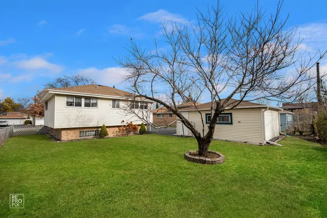 a view of a house with backyard and a tree
