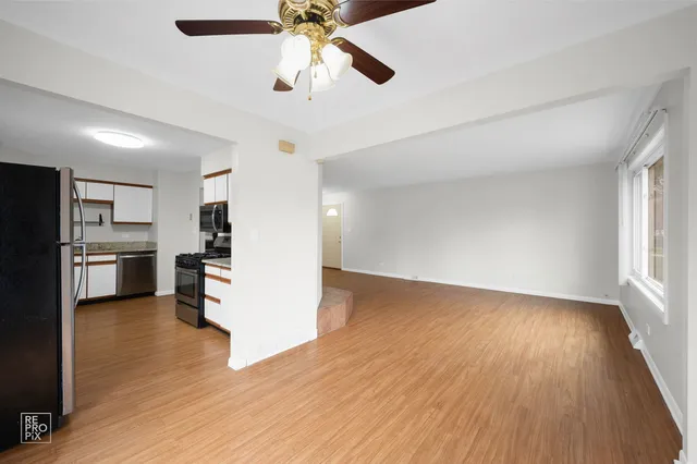 a view of kitchen and wooden floor in an empty room