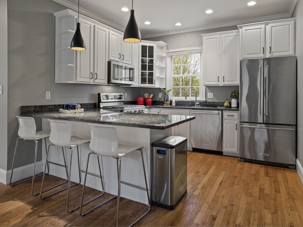 44 A Orchardhill Road, Unit A Boston, MA 02130 - Photo 6 of 37 a kitchen with stainless steel appliances granite countertop a kitchen island hardwood floor sink and stove