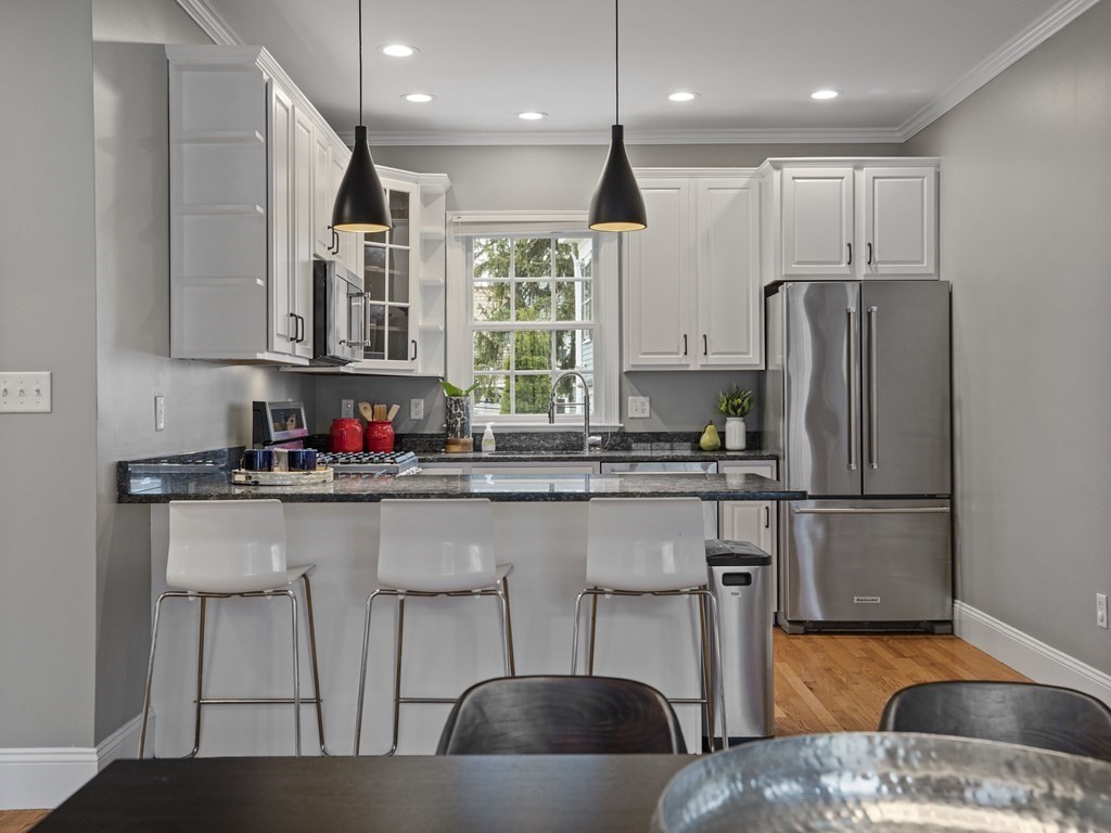 44 A Orchardhill Road, Unit A Boston, MA 02130 - Photo 7 of 37 a kitchen with stainless steel appliances granite countertop a table chairs refrigerator and sink
