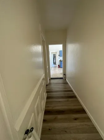 a view of entryway and hall with wooden floor