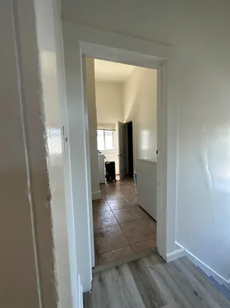 a view of a hallway view with wooden floor and a living room