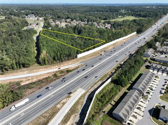 an aerial view of a residential houses with outdoor space and trees