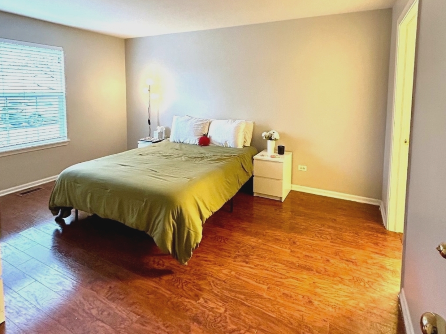 978 North Village Drive, Unit 2 Round Lake Beach, IL 60073 - Photo 2 of 7 a bedroom with a bed and wooden floor