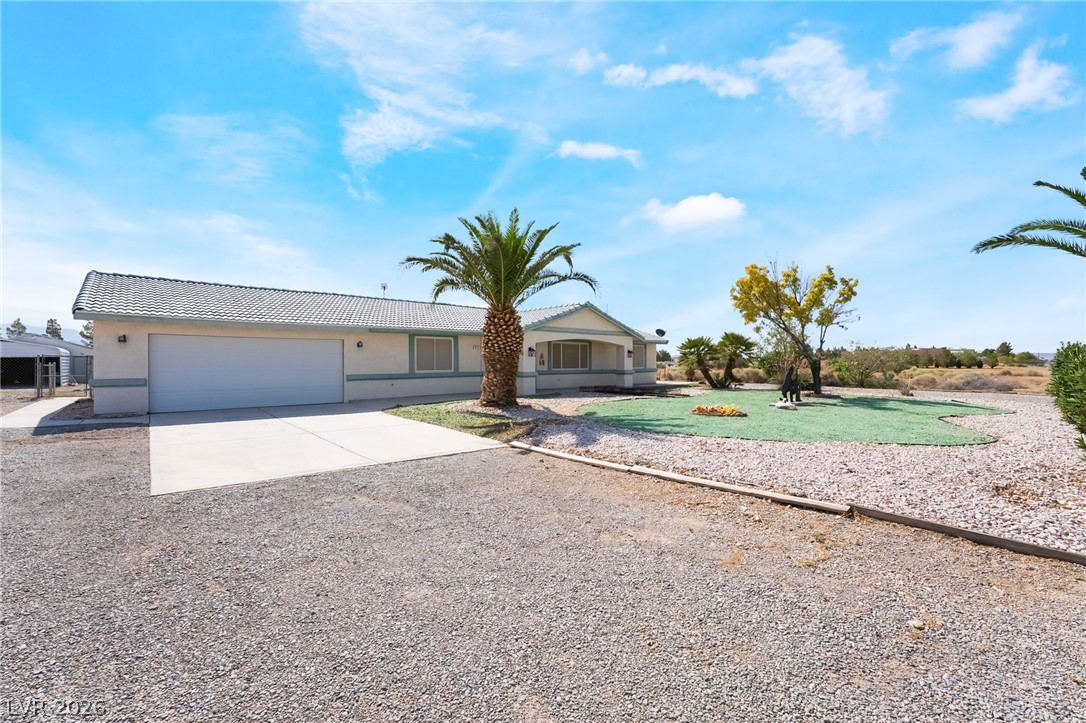 3631 South Blagg Road Pahrump, NV 89048 - Photo 5 of 47 A well-maintained single-story residence with a concrete driveway and desert landscaping.