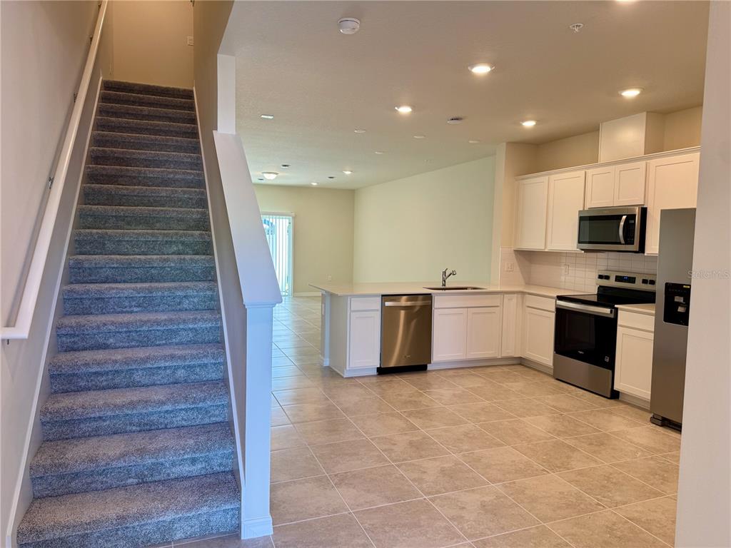 3059 Emerald Acrs Lane Sanford, FL 32771 - Photo 3 of 24 a kitchen with white cabinets and stainless steel appliances