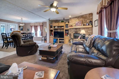 a living room with furniture a ceiling fan and a window