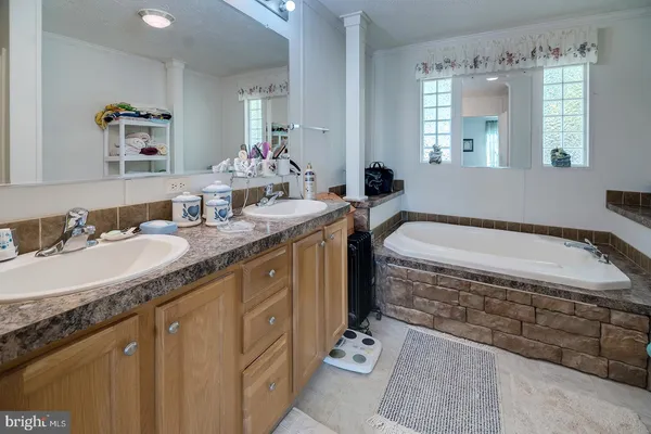 a spacious bathroom with a granite countertop sink mirror and bathtub