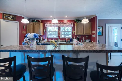 a kitchen with granite countertop wooden cabinets and a dining table