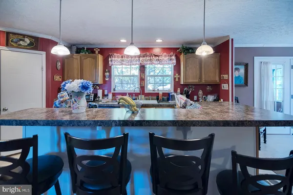 a kitchen with granite countertop wooden cabinets and a dining table