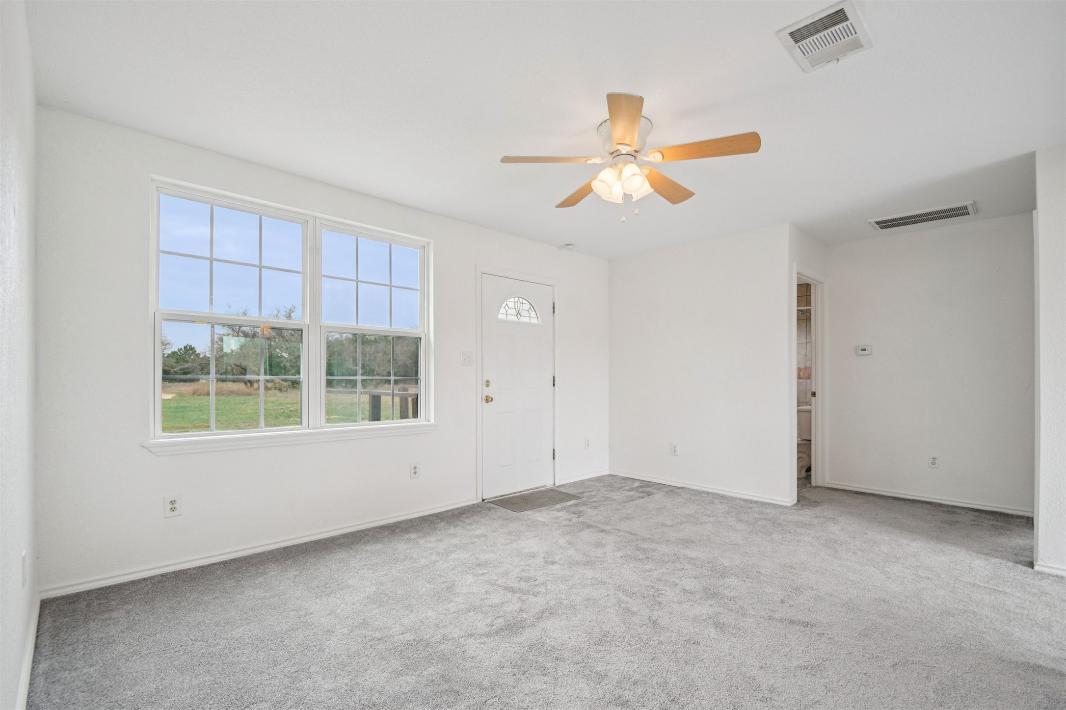 1470 Oak Grove Road Leander, TX 78641 - Photo 4 of 38 an empty room with a window and a ceiling fan