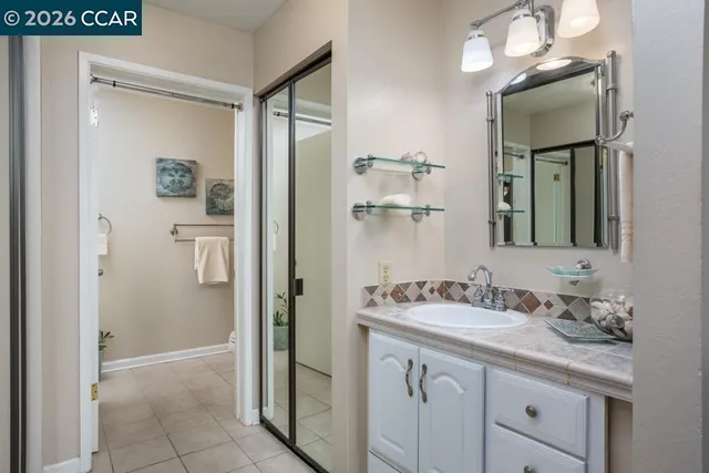 a bathroom with a sink a vanity a mirror and a shower