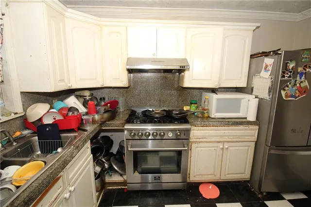 a kitchen with a stove a refrigerator and a window