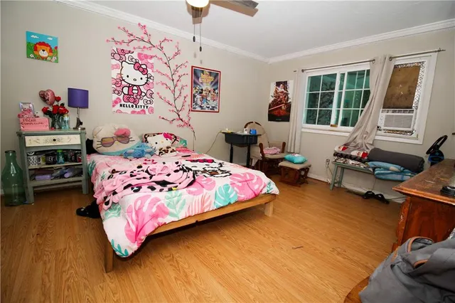 a bedroom with a bed and wooden floor