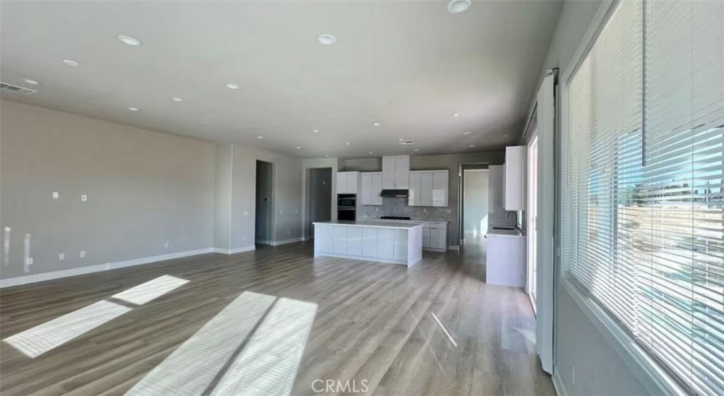 12925 Davona Dale Road Apple Valley, CA 92308 - Photo 5 of 14 a open kitchen with white cabinets and wooden floor