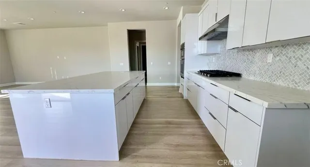 a large kitchen with stainless steel appliances granite countertop a refrigerator a sink and a stove