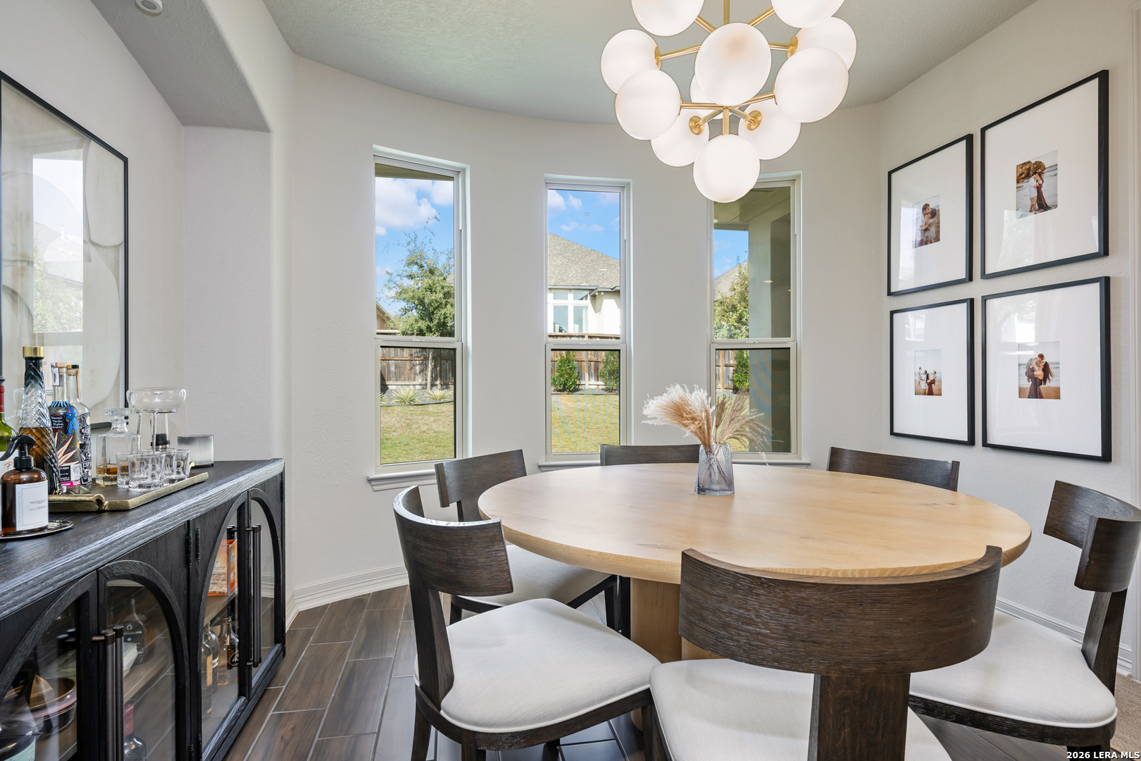 8527 Nichols Rim Boerne, TX 78015 - Photo 13 of 33 a dining room with wooden floor a chandelier a glass table and chairs