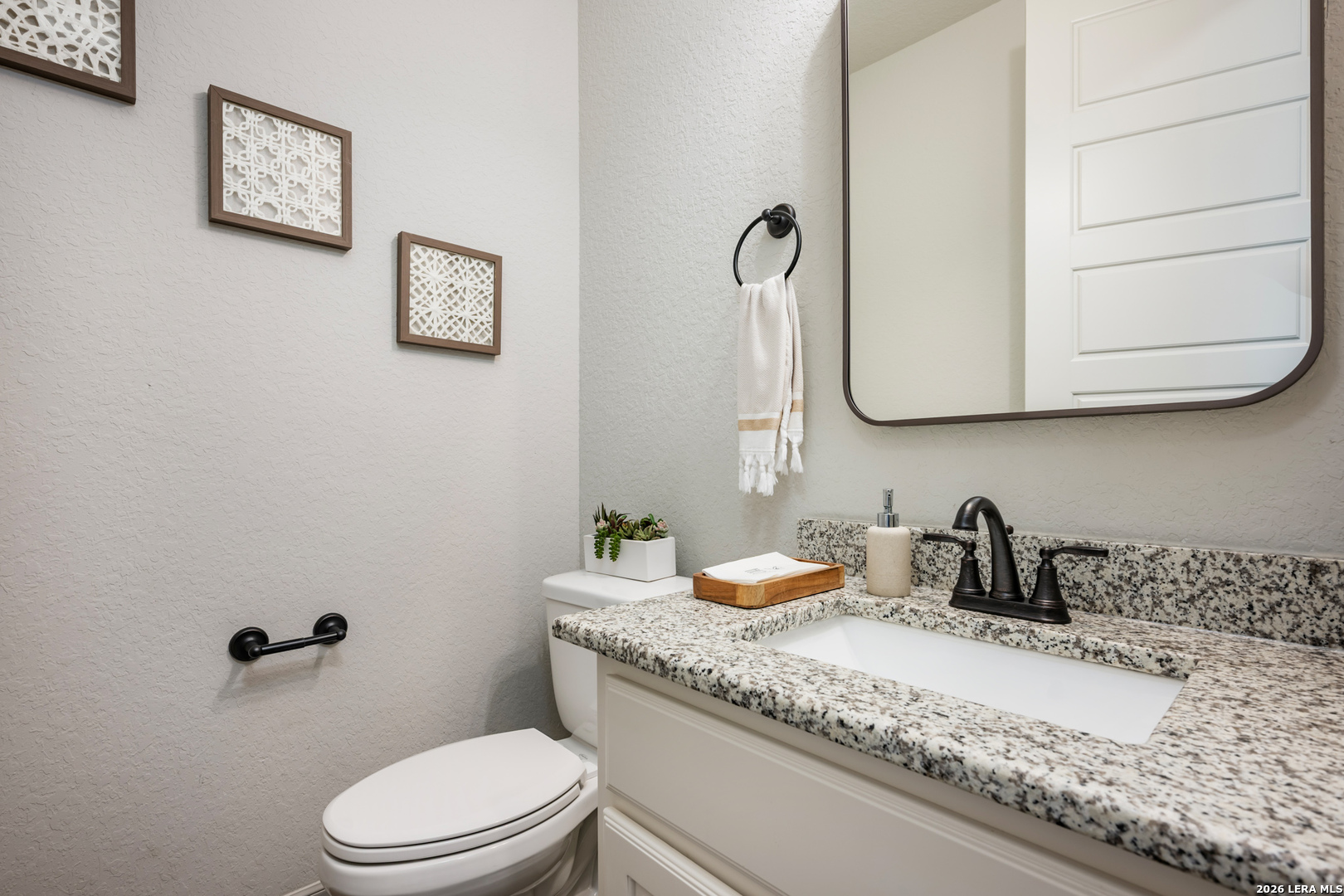 8527 Nichols Rim Boerne, TX 78015 - Photo 15 of 33 a bathroom with a granite countertop sink mirror vanity and toilet