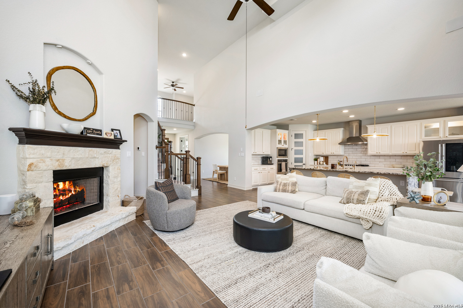 8527 Nichols Rim Boerne, TX 78015 - Photo 2 of 33 a living room with furniture a fireplace and kitchen view