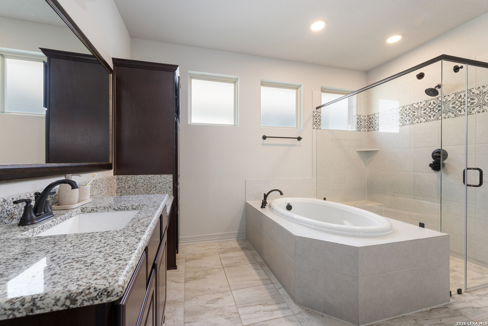 8527 Nichols Rim Boerne, TX 78015 - Photo 22 of 33 a bathroom with a granite countertop tub sink and mirror