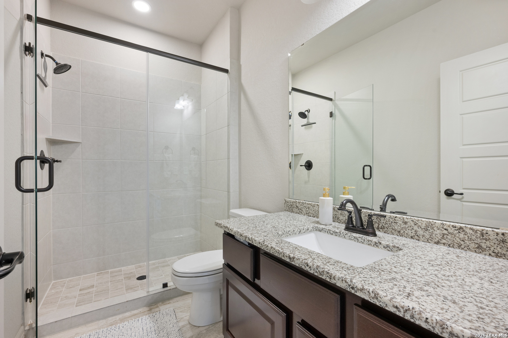 8527 Nichols Rim Boerne, TX 78015 - Photo 28 of 33 a bathroom with a granite countertop sink a toilet and shower